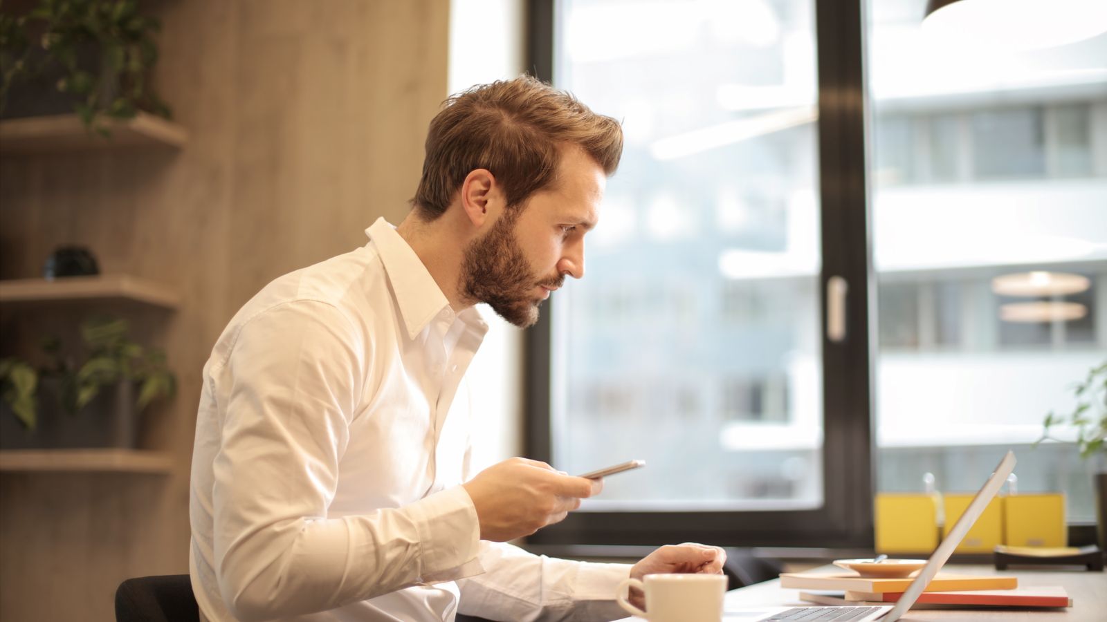 Practice owner reviewing messages at a desk with coffee