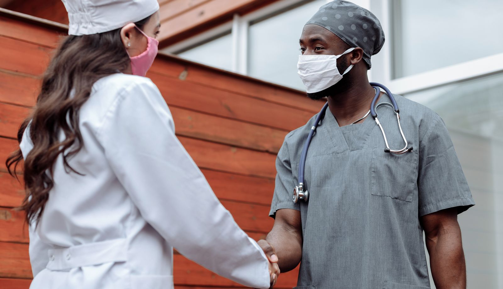 Two healthcare professionals shaking hands in partnership
