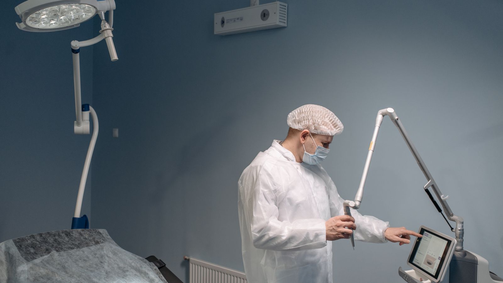Clinician operating laser equipment in a treatment room