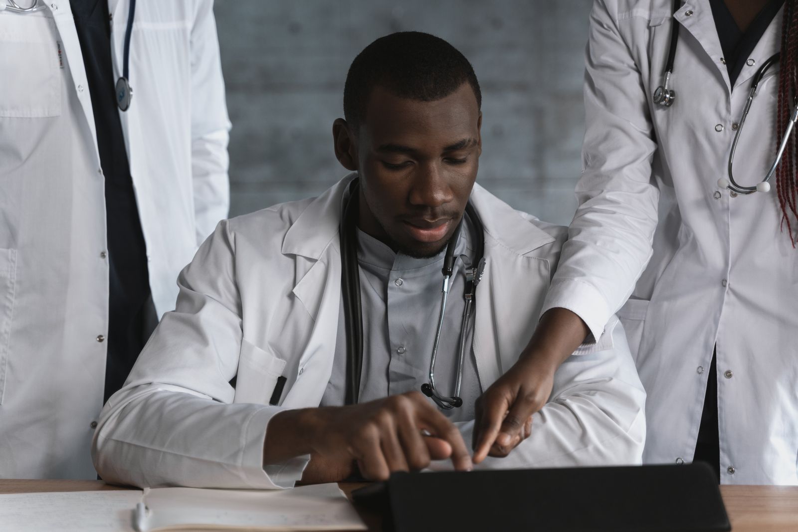 Physicians discussing patient care coordination in a clinic hallway