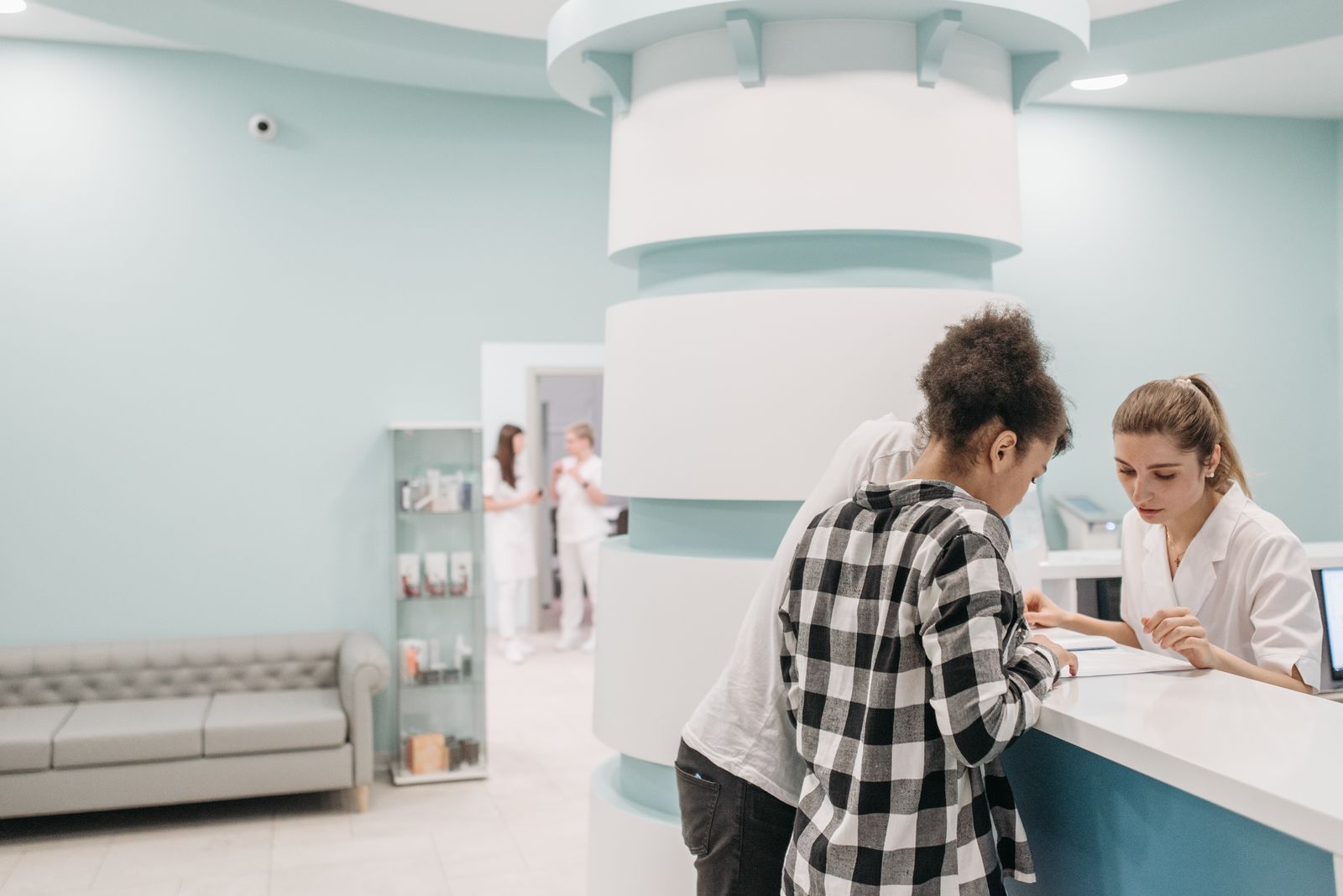 Clinic coordinator managing schedules at a busy reception desk