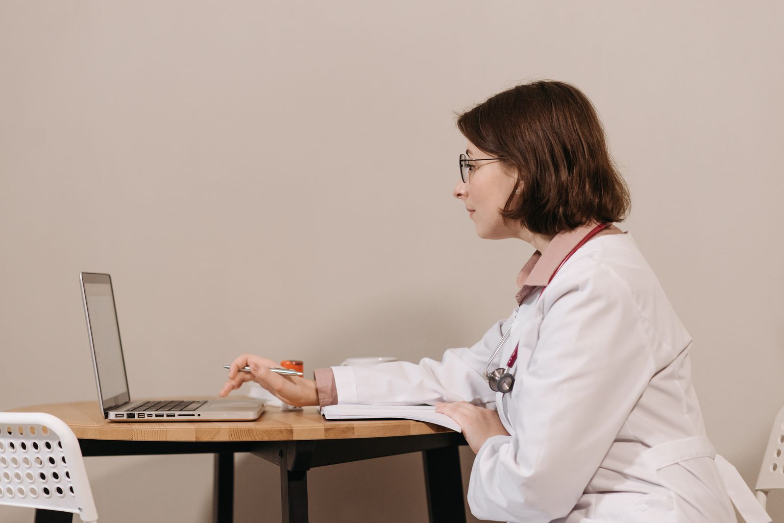 Physician reviewing research documentation on a computer in a clinic office