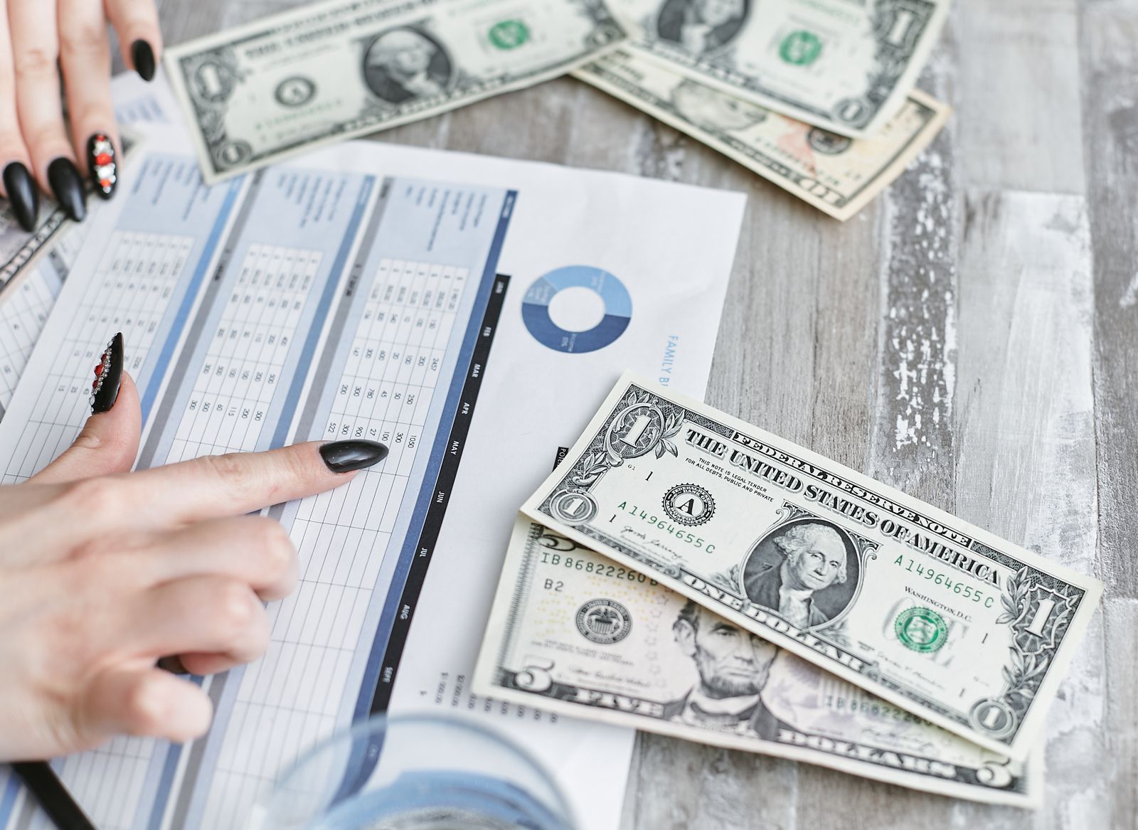 Hands reviewing financial statements and revenue figures at a desk