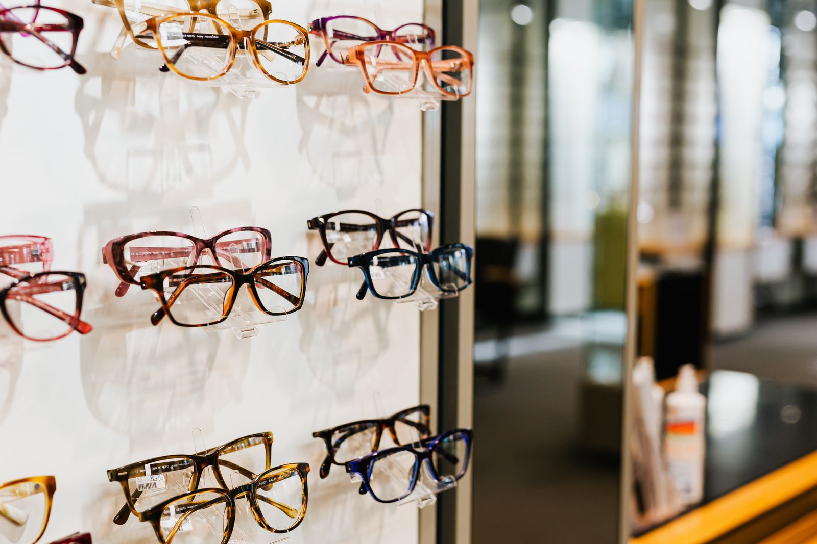 Assorted eyeglasses displayed on shelves in an optical boutique