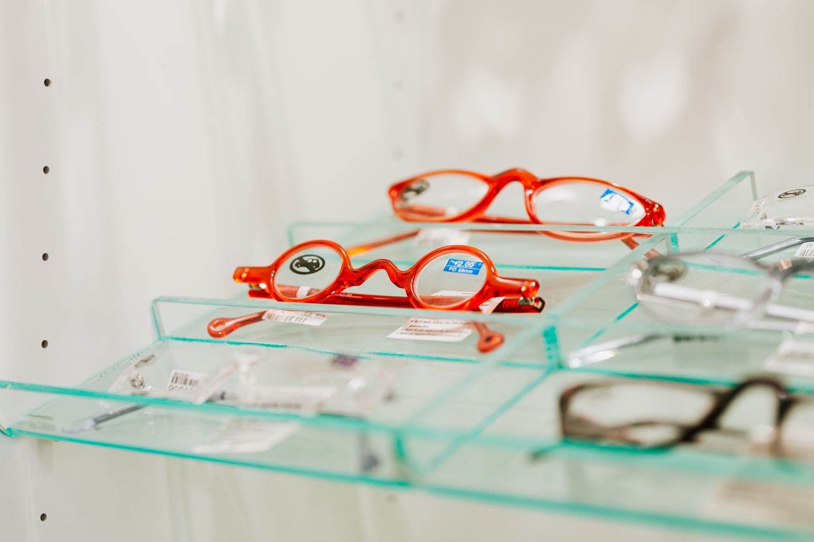 Eyeglasses arranged on a display shelf in an optical shop