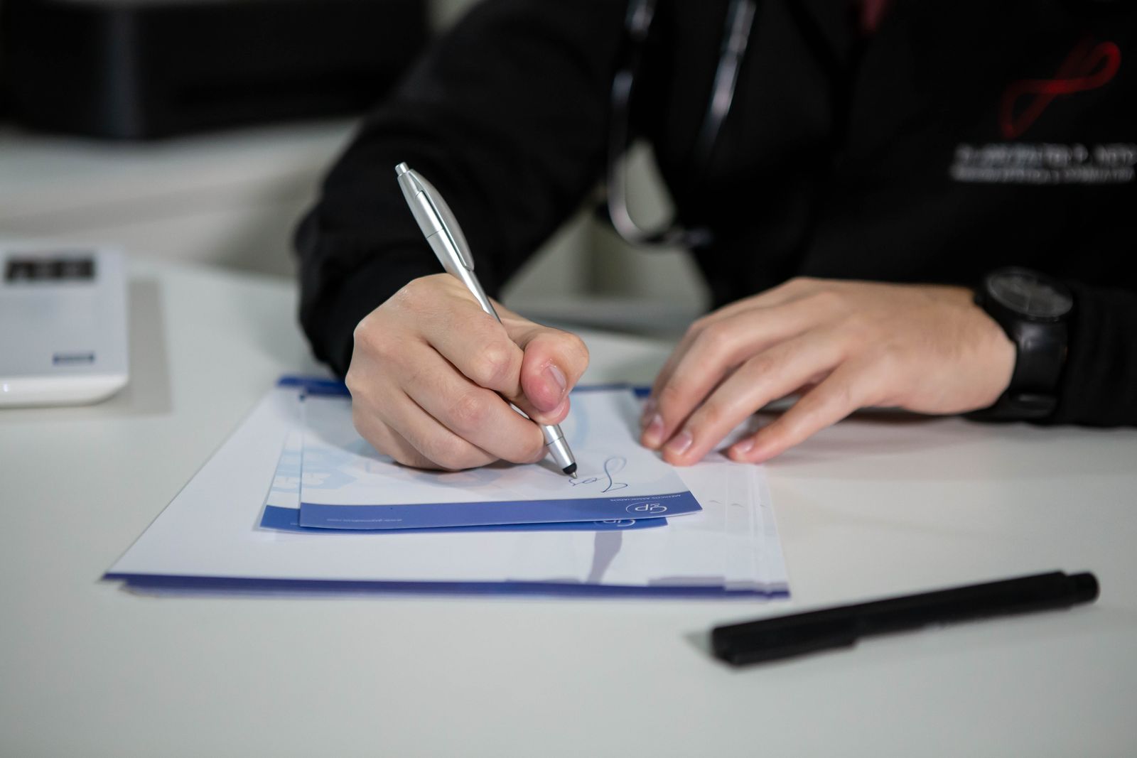 Doctor working through insurance reimbursement paperwork at a desk