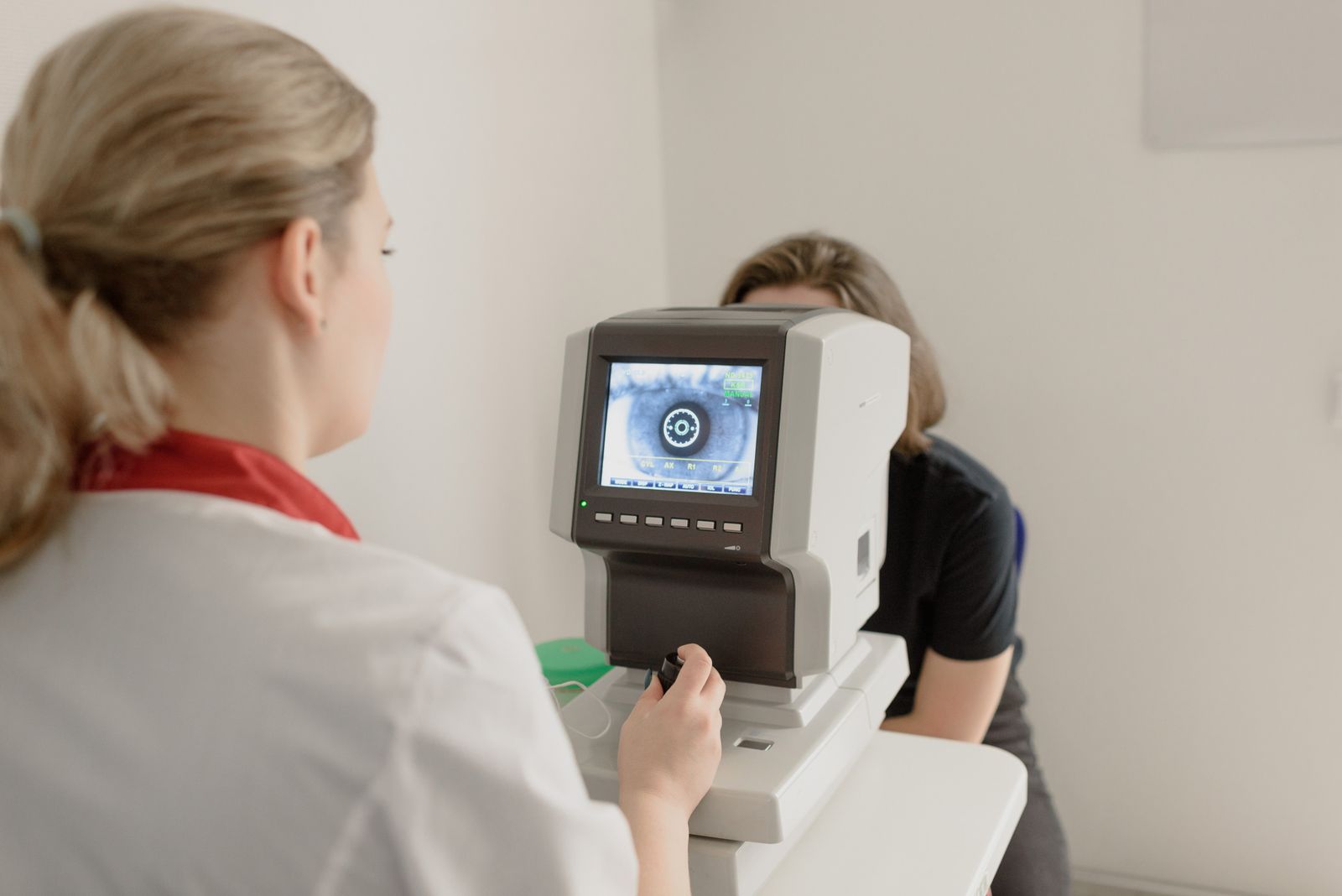 Optometrist checking a patient's eyesight during a friendly exam
