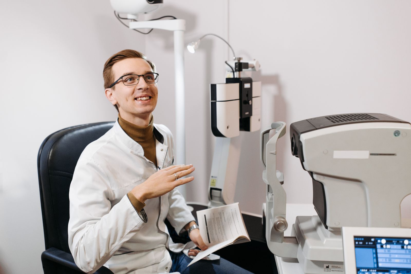 Optometrist smiling with a young patient during an eye exam
