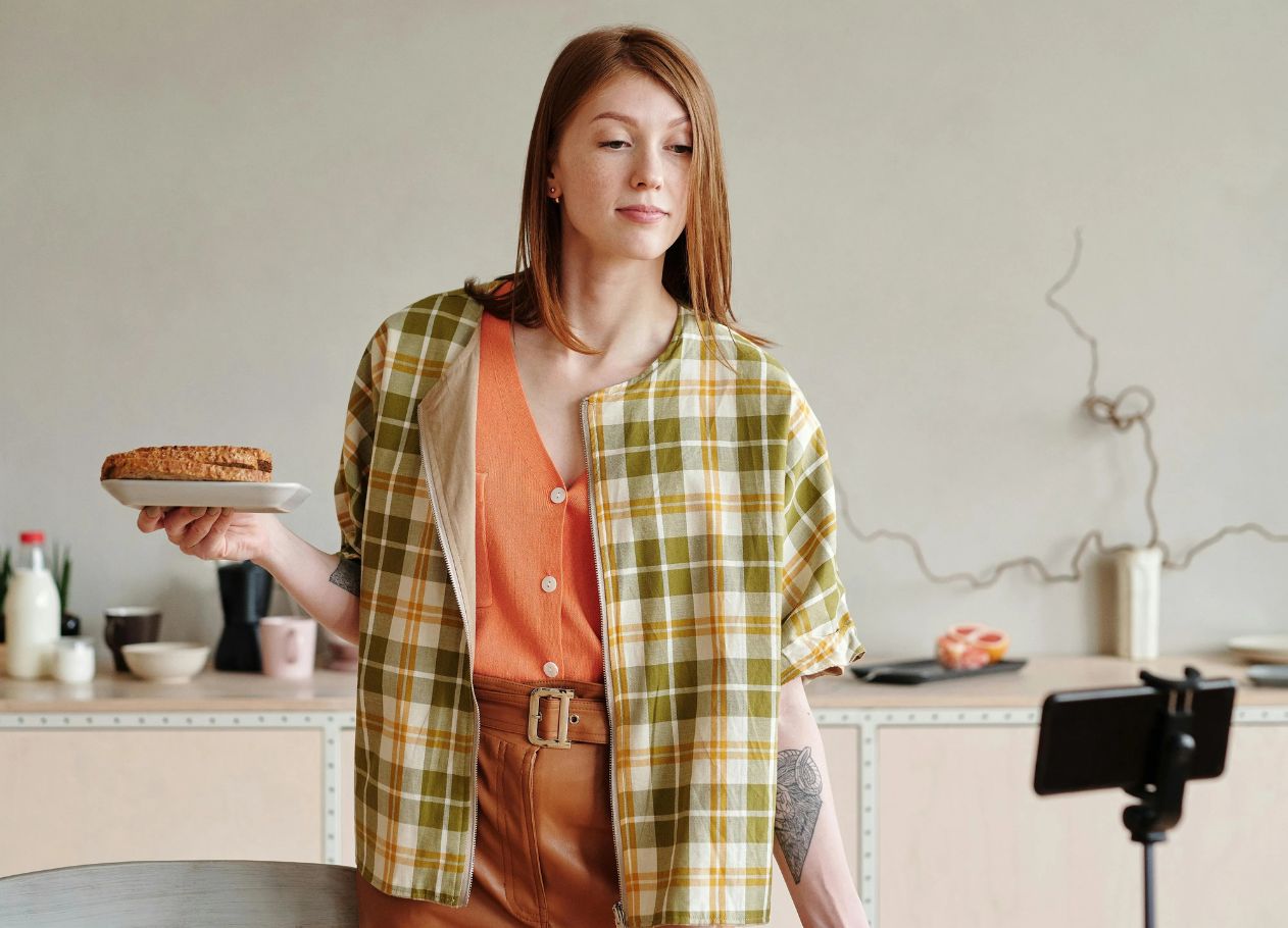 woman showing her cooking to a phone on a tripod
