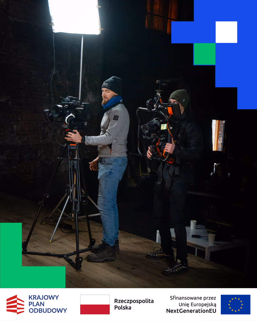 Dwóch operatorów kamer filmowych pracujących na ciemnym planie z oświetleniem studyjnym.