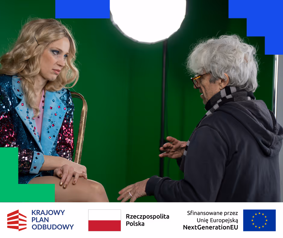 Kobieta w błyszczącej, cekinowej marynarce rozmawia z mężczyzną w czarnej bluzie i szaliku, na zielonym tle z jasnym światłem.