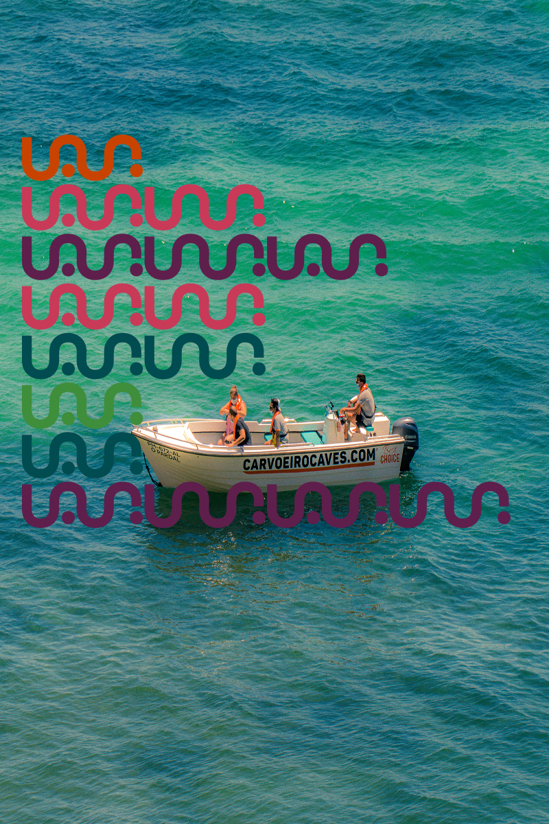 Cuatro personas en un bote motor pequeñas en el agua azul verde del mar.