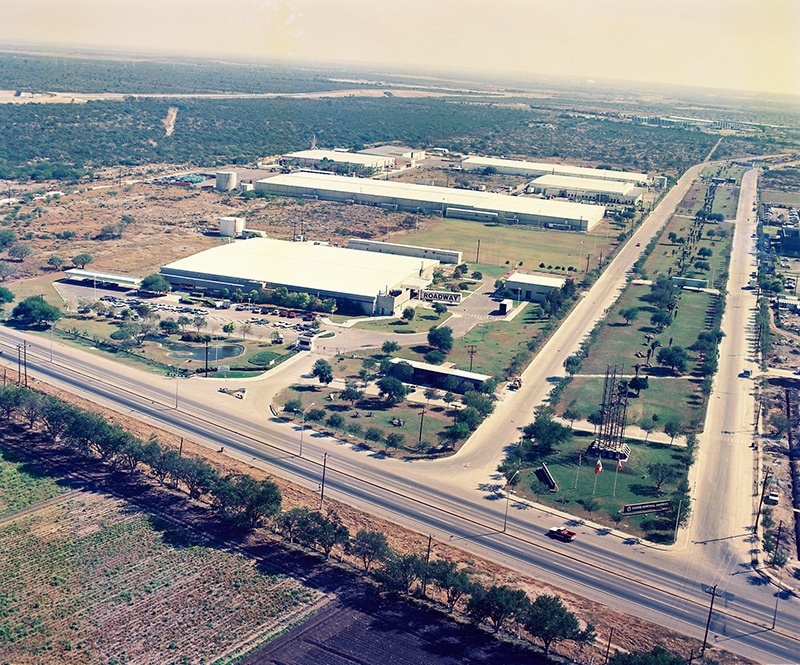 Vista aérea del Parque PIMSA, con naves blancas junto a la carretera.