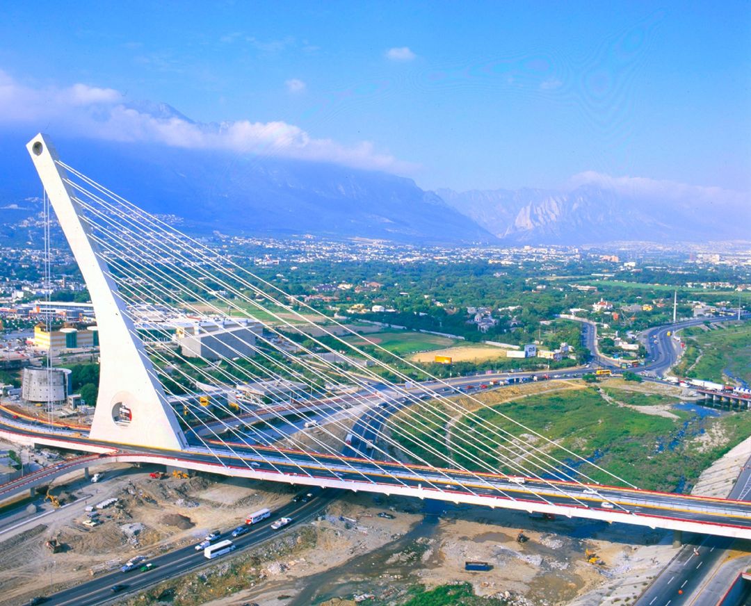 Puente atirantado de la Unidad, con pilón blanco, vialidades y montañas.