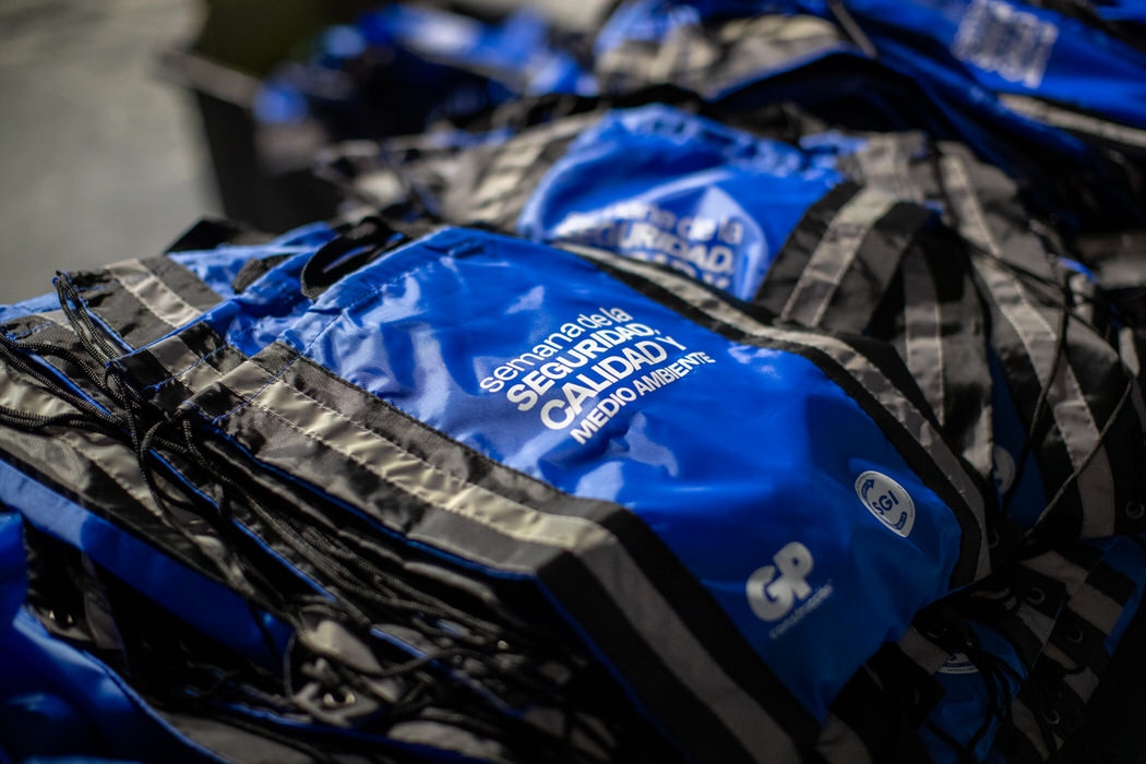 Mochilas azules de la Semana de la Seguridad, Calidad y Medio Ambiente apiladas.