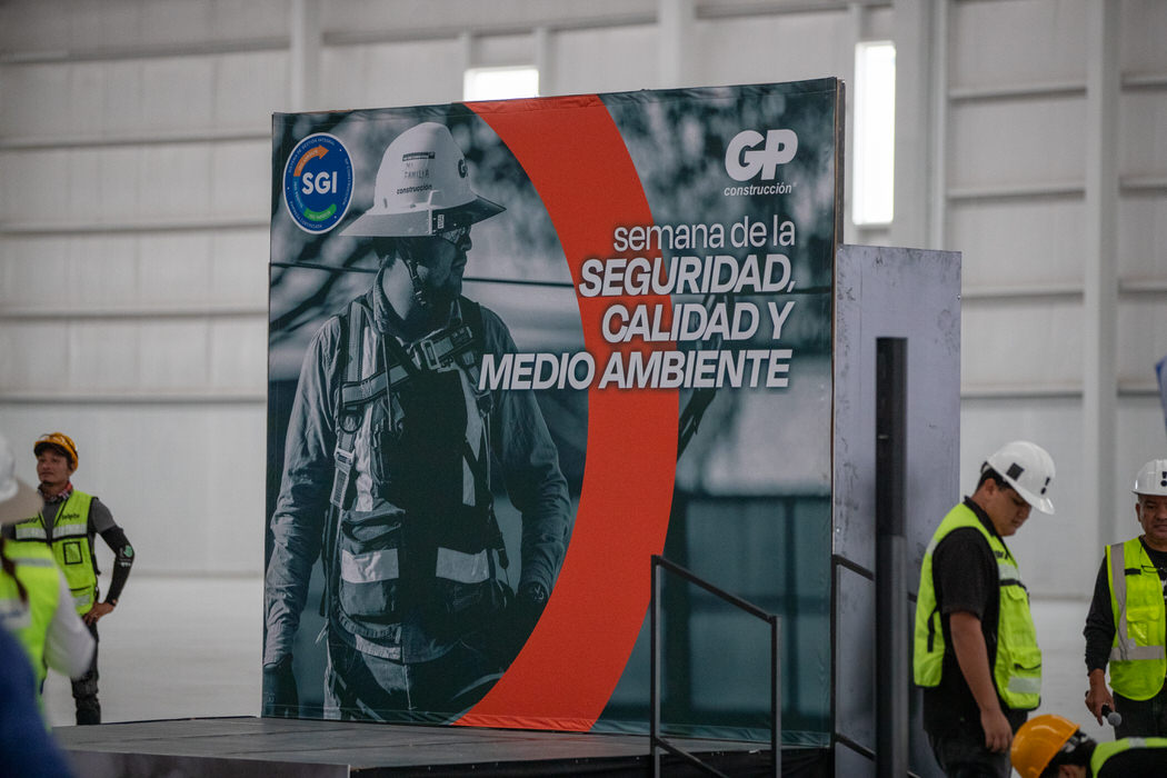Letrero de la Semana de la Seguridad, Calidad y Medio Ambiente sobre una tarima.