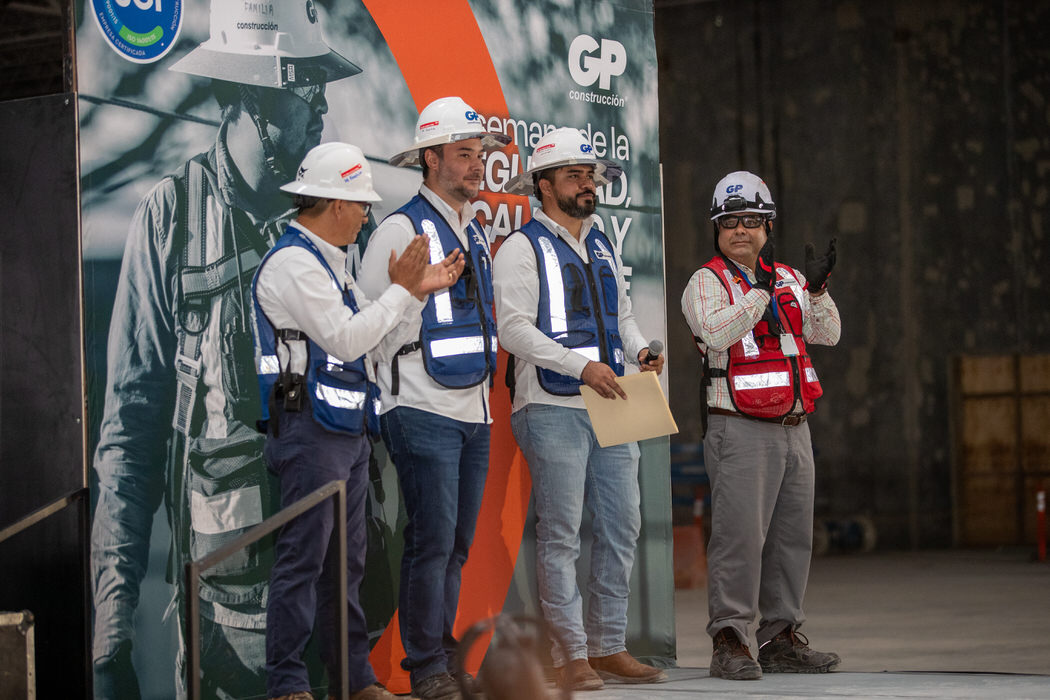 Cuatro personas con chaleco aplauden en el escenario de la Semana de la Seguridad.