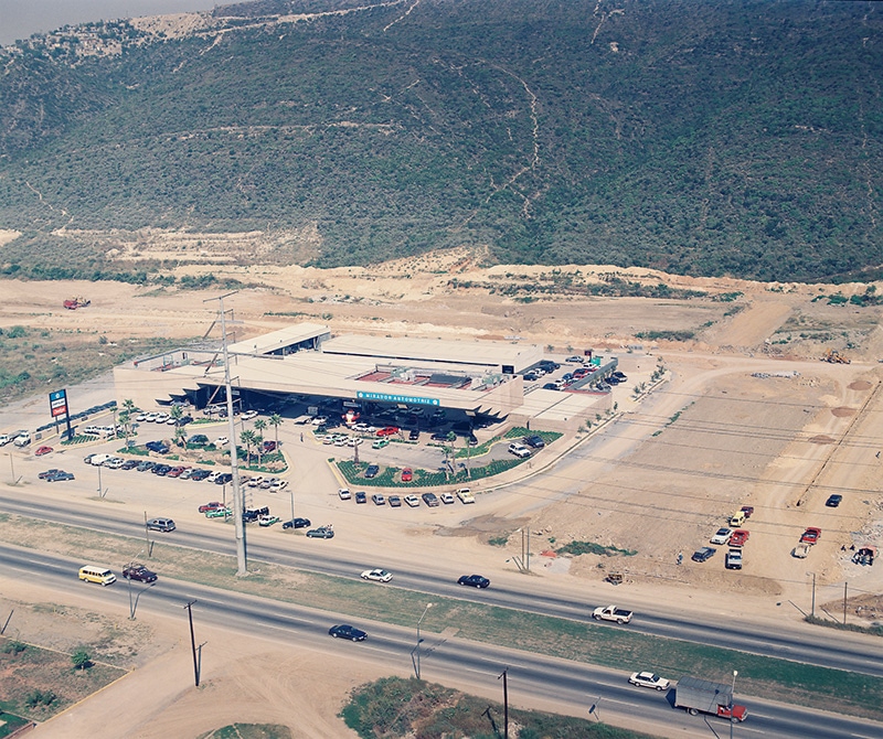 Vista aérea de la instalación Chrysler, con estacionamiento junto a la avenida.
