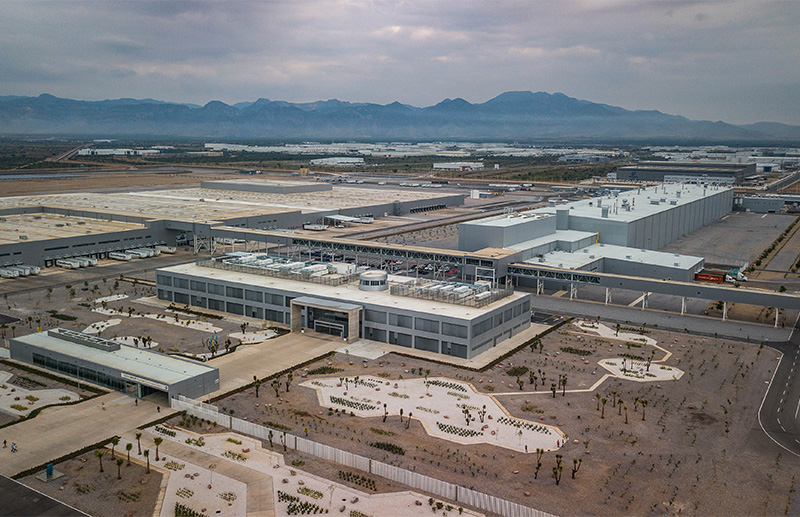 Vista aérea del complejo BMW, con naves grises en un valle.