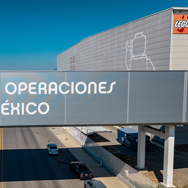 Puente con la leyenda Operaciones México frente a la nave de LEGO.