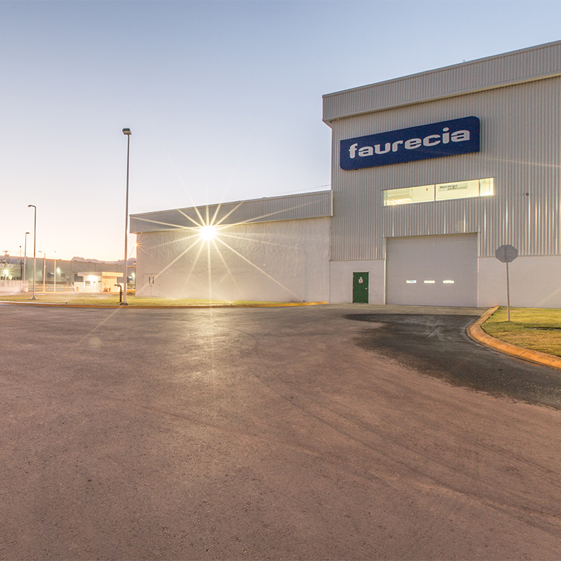 Nave de Faurecia al atardecer, con el logotipo y una puerta de andén.
