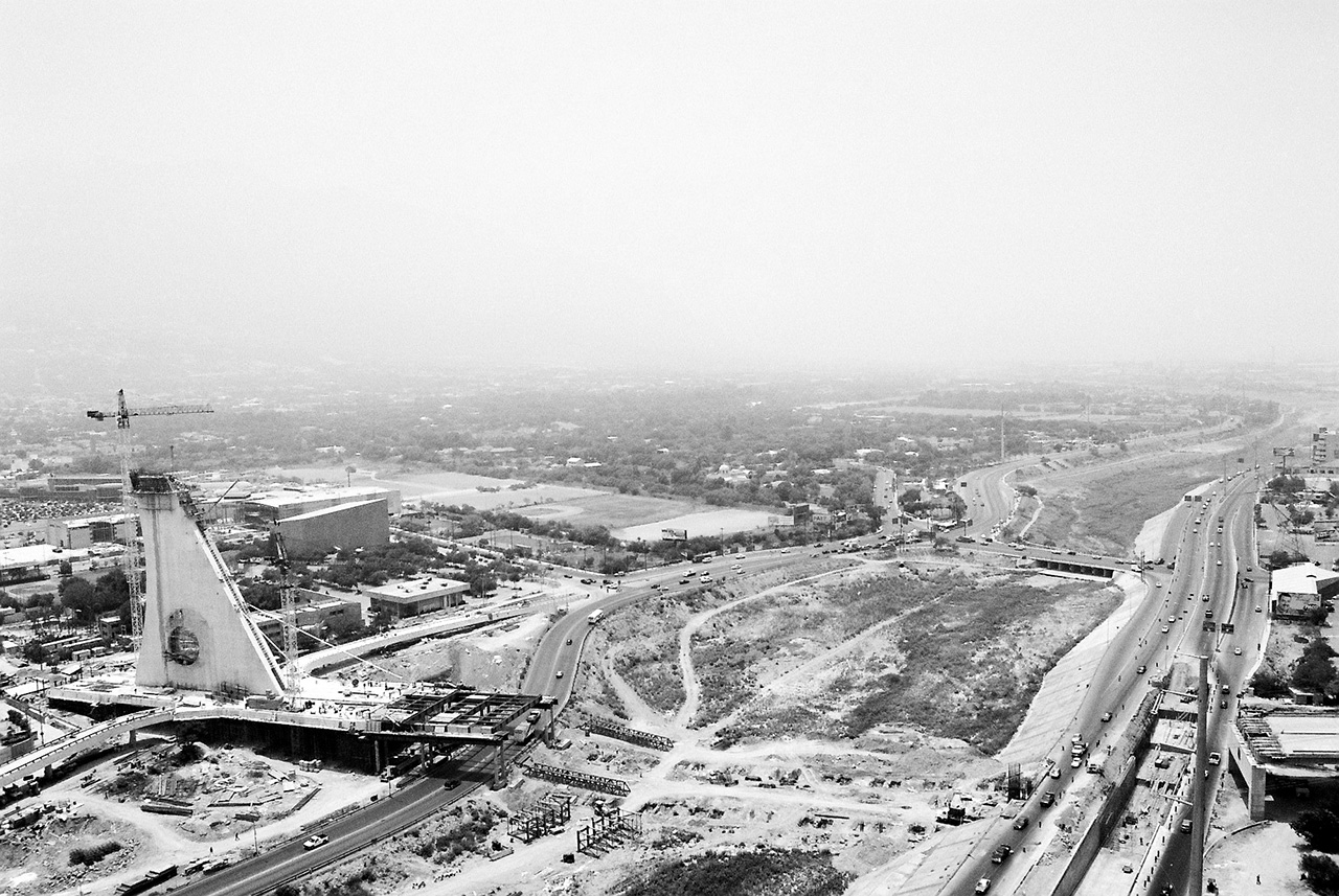 Vista aérea en blanco y negro de un puente en construcción y un distribuidor vial.