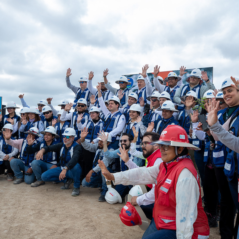 Cuadrilla de GP saluda en obra, con cascos blancos y chalecos de la empresa.
