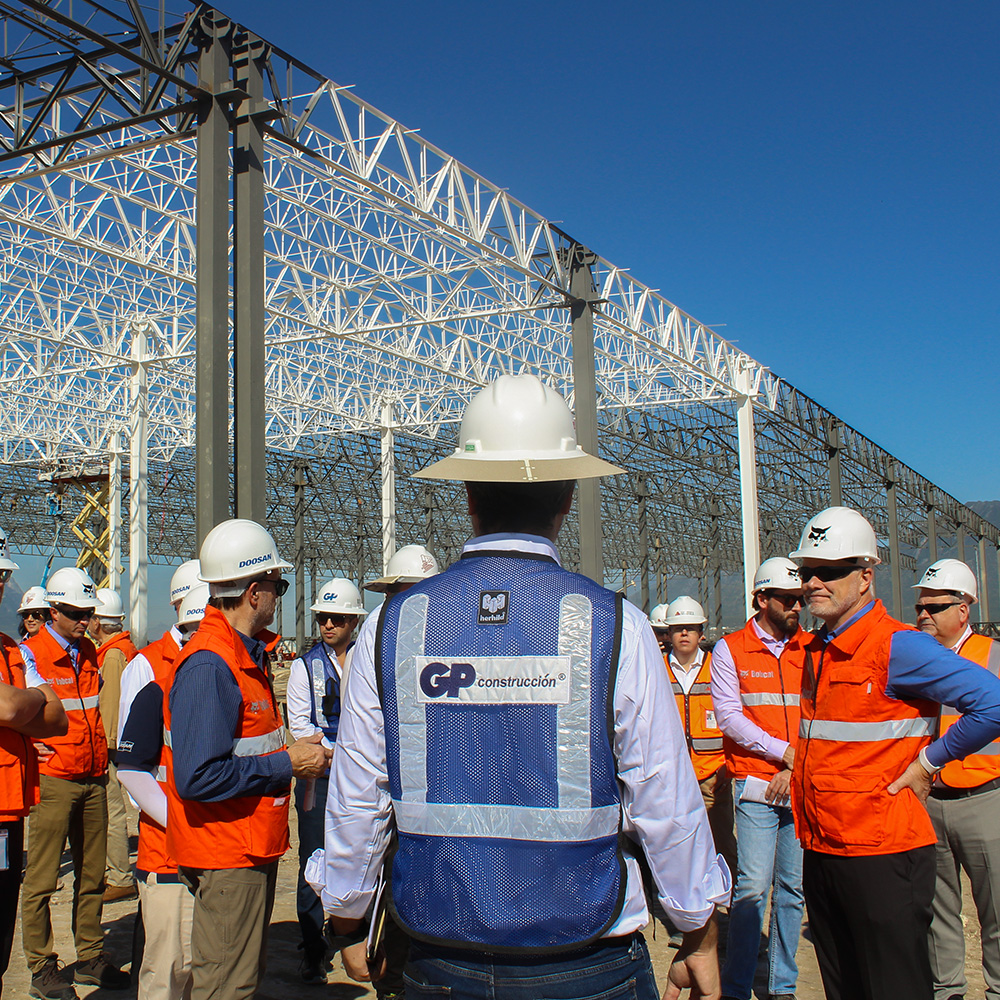 Supervisores de GP Construcción se reúnen bajo la estructura metálica de una nave.