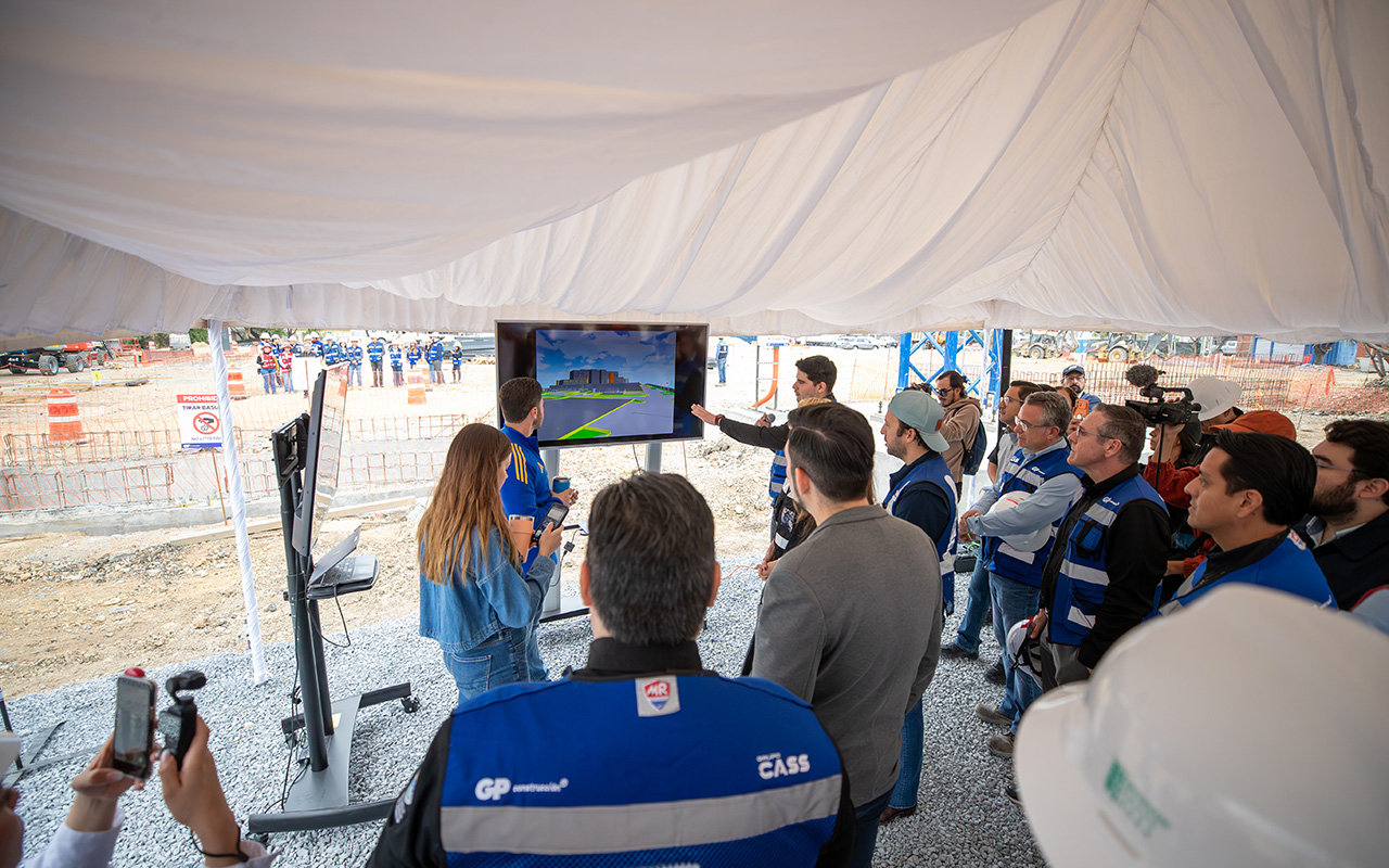Presentación de un modelo 3D en pantalla, bajo una carpa, ante el equipo de obra.