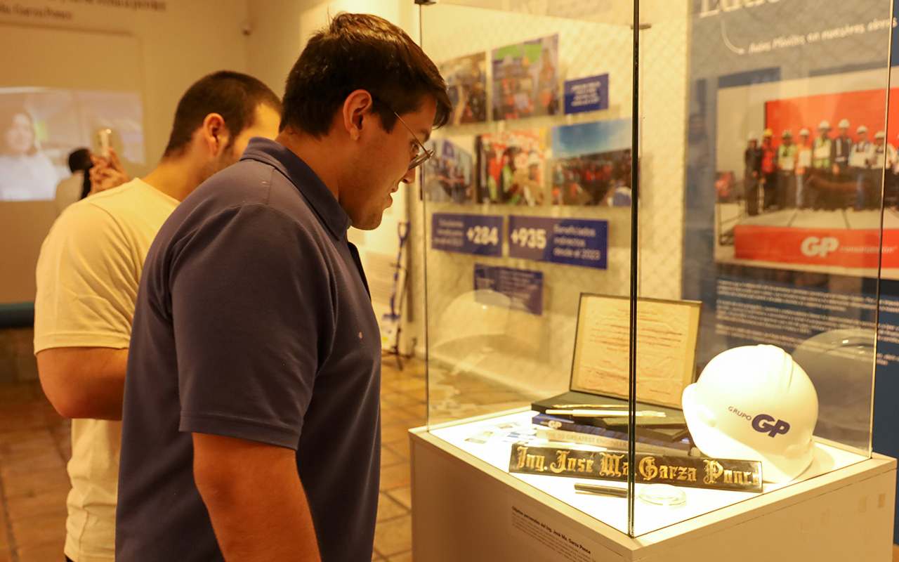 Visitante observa una vitrina con casco GP y placa del ingeniero José Ma. Garza Ponce.