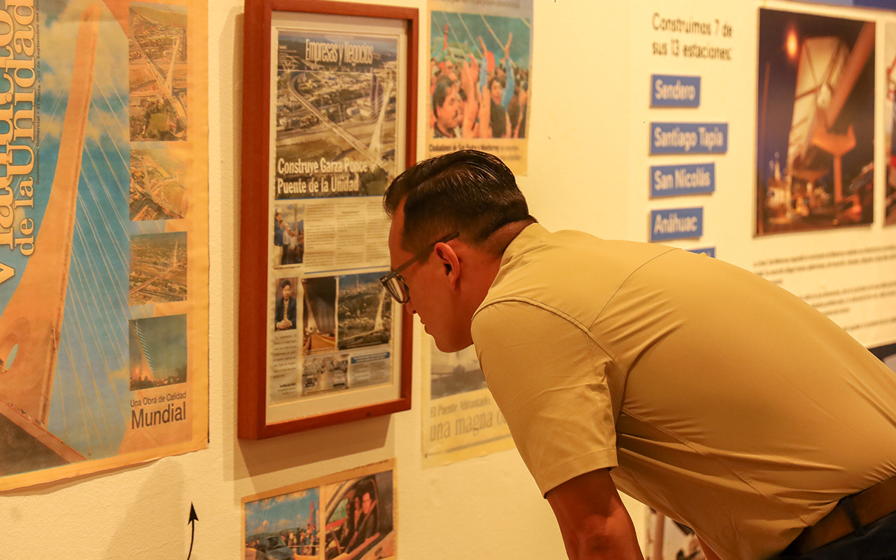 Visitante lee un recorte del Puente de la Unidad en la exposición del museo.