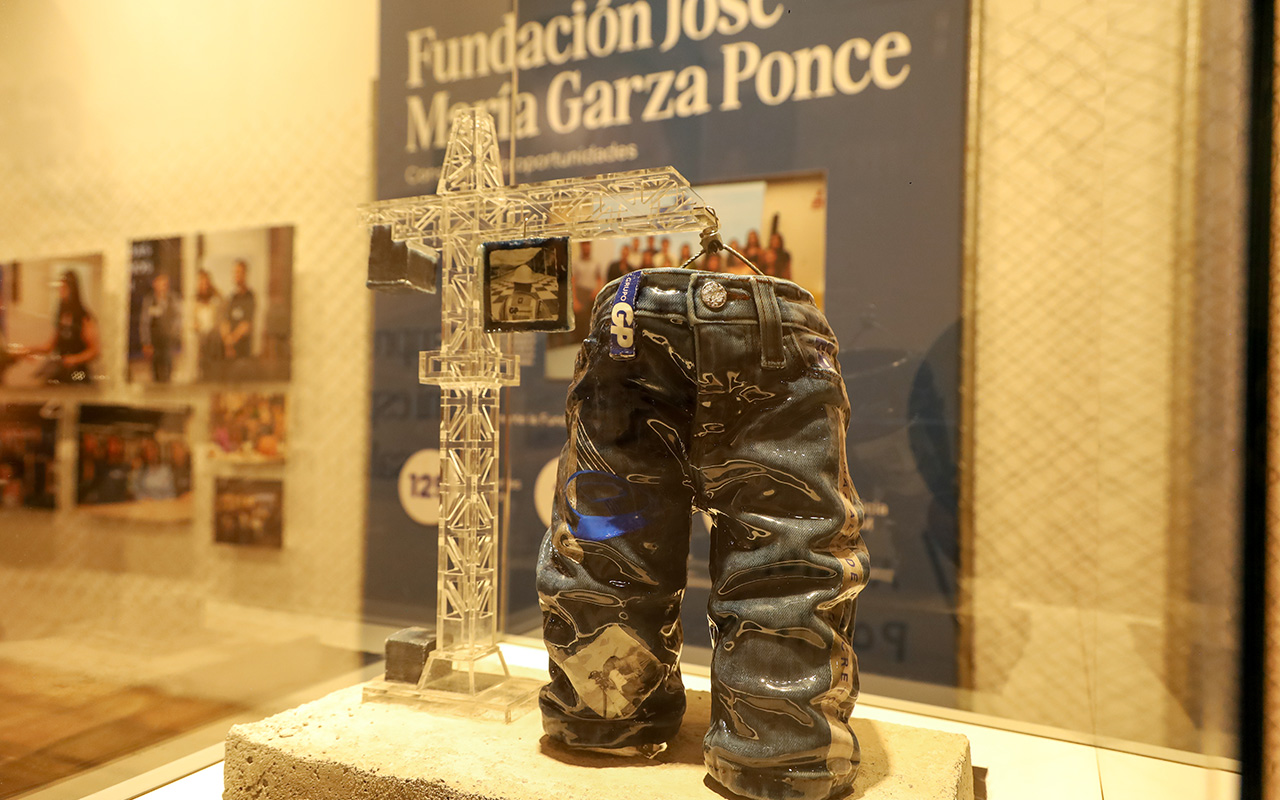 Escultura de un pantalón y una torre frente al cartel de la Fundación José María Garza Ponce.