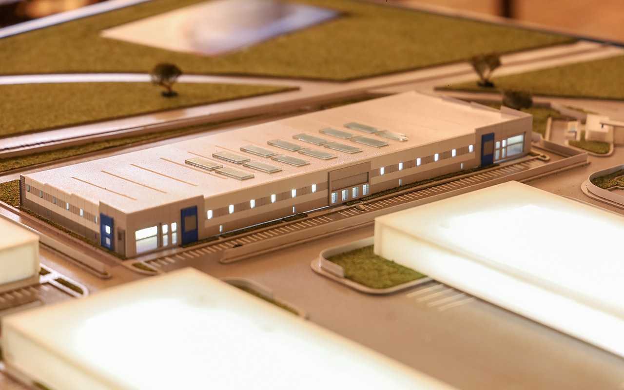Maqueta de una nave industrial alargada, con domos y vialidades a su alrededor.