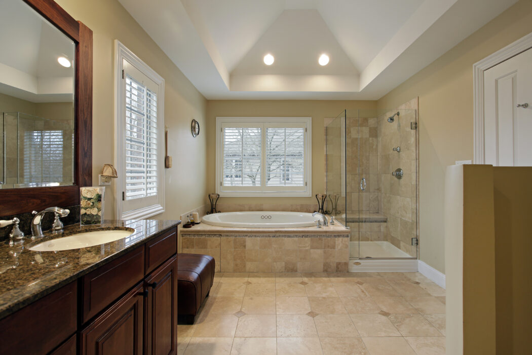 Luxury bathroom featuring granite countertop vanity, tiled floors, and walk-in glass shower