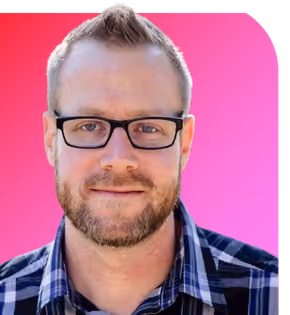 Smiling man with short hair, beard, glasses, and plaid shirt on a white background with red edge.