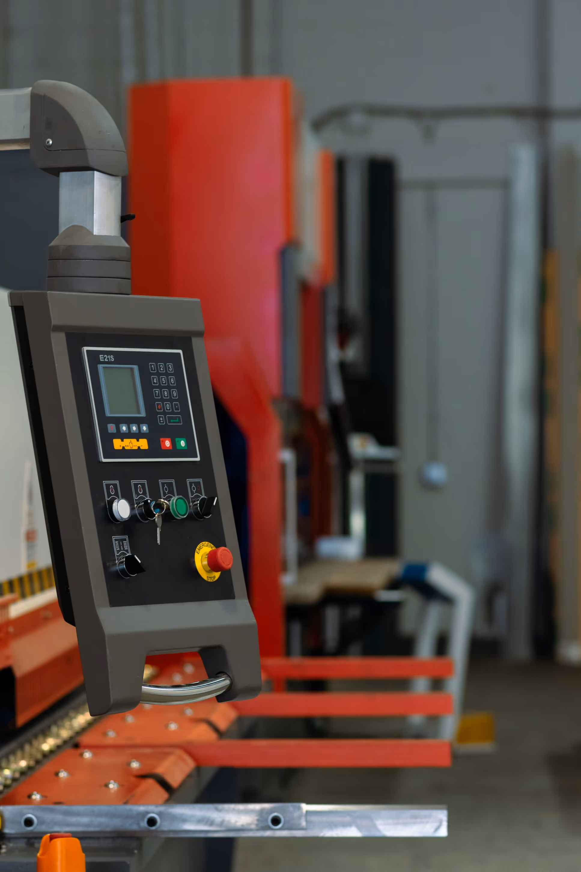 Close-up of a machine control panel with buttons and a digital display in an industrial setting.