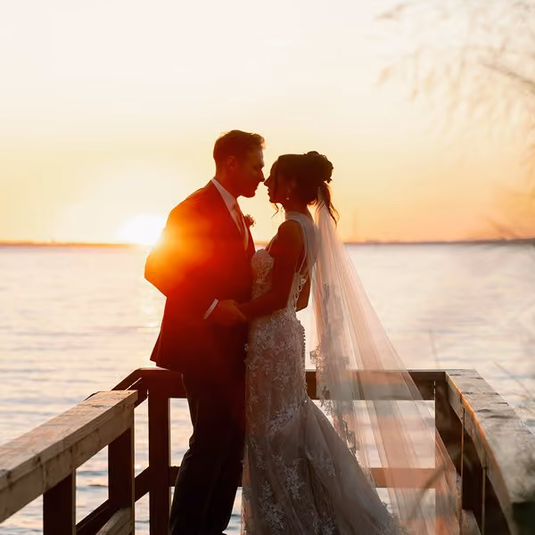 Bride and groom sharing a moment on a waterfront dock at sunset at Chesapeake Bay Beach Club