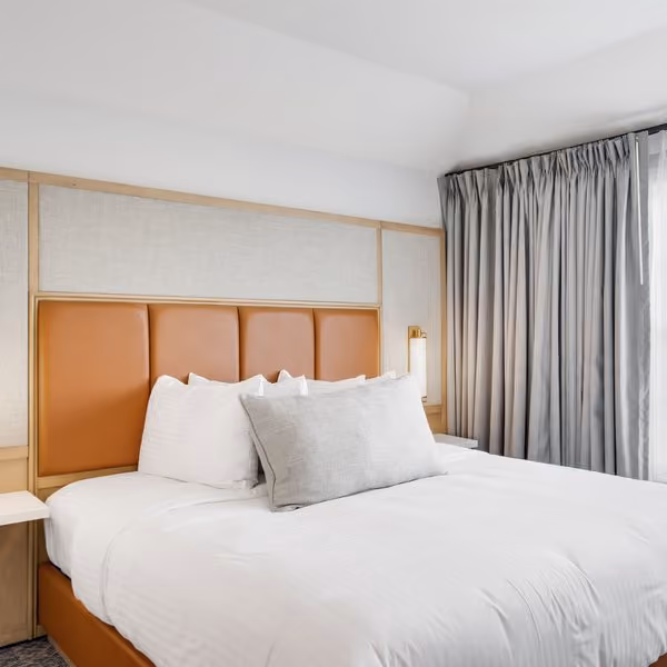 Manor Suite guest room with a leather headboard and king bed at The Inn