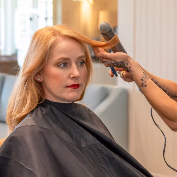 Stylist blow-drying and styling a client's hair at The Spa salon