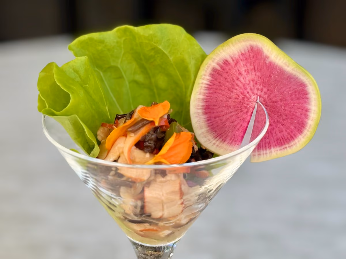 Chilled seafood tartare served in a martini glass with butter lettuce and a watermelon radish slice at Vue