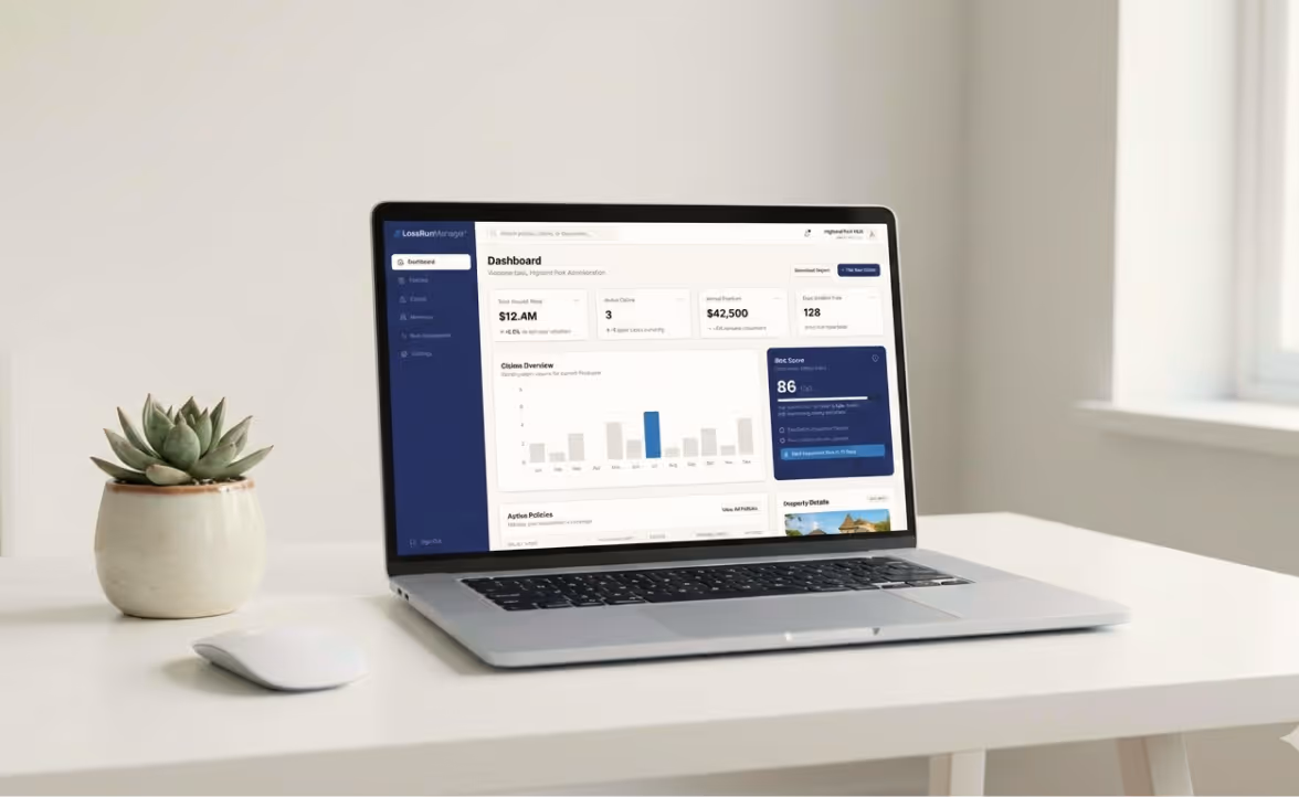 Open laptop on a white desk displaying a dashboard with charts and data, next to a small potted succulent and a white wireless mouse.