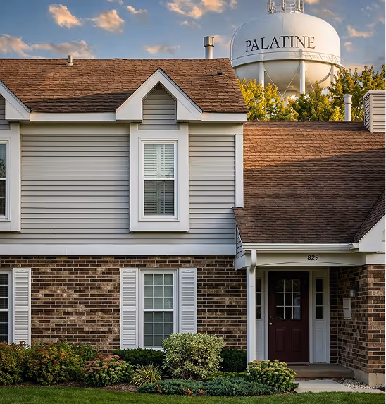 Two-story house with brick and siding exterior, brown roof, and a maroon front door, with a water tower labeled 'PALATINE' visible behind trees.