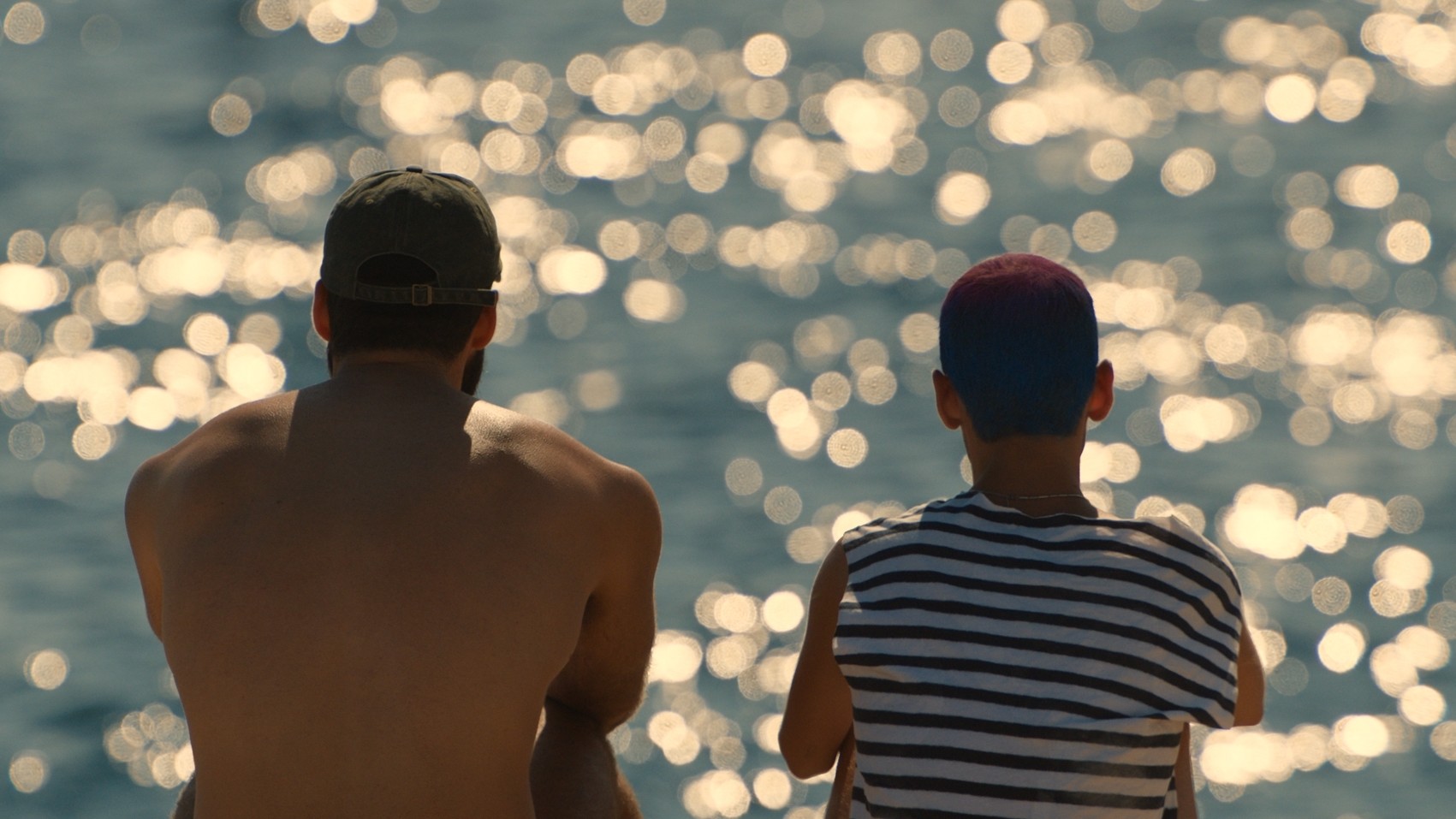 Demos and Nikitas sitting together overlooking the sparkling Aegean Sea