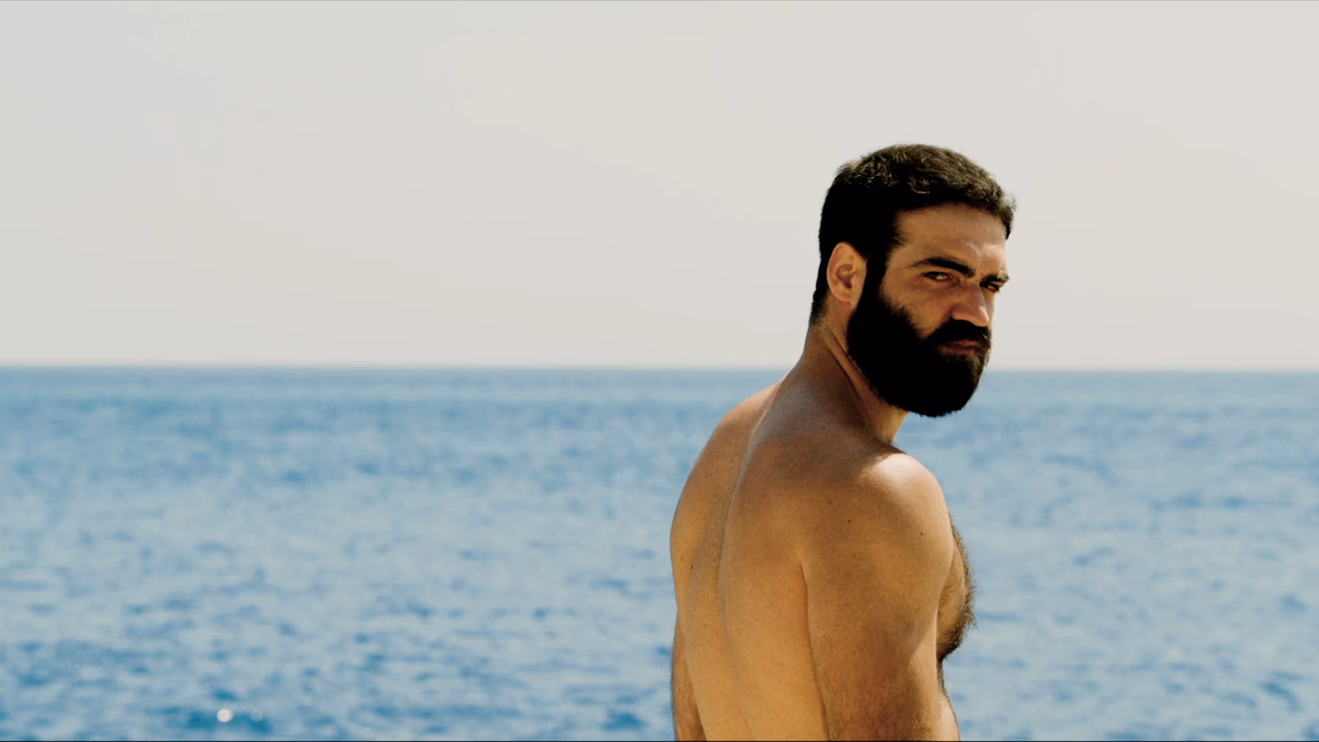 Nikitas standing by the sea in The Summer With Carmen