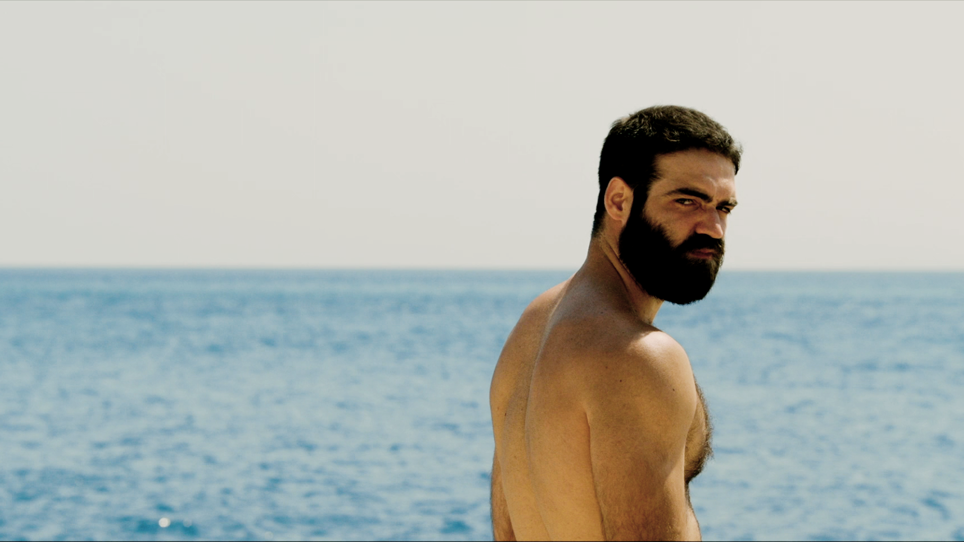 Nikitas standing by the sea in The Summer With Carmen