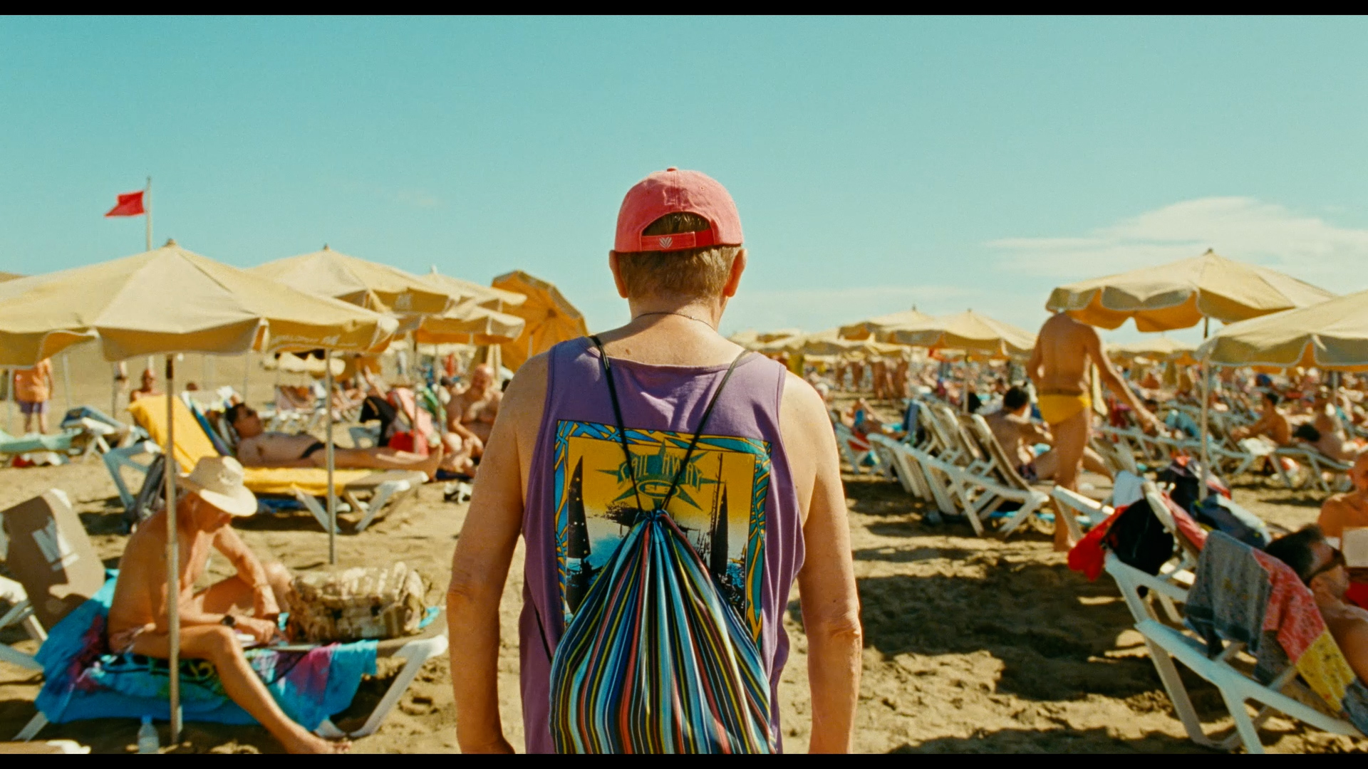 Vicente walks along a crowded beach in Maspalomas