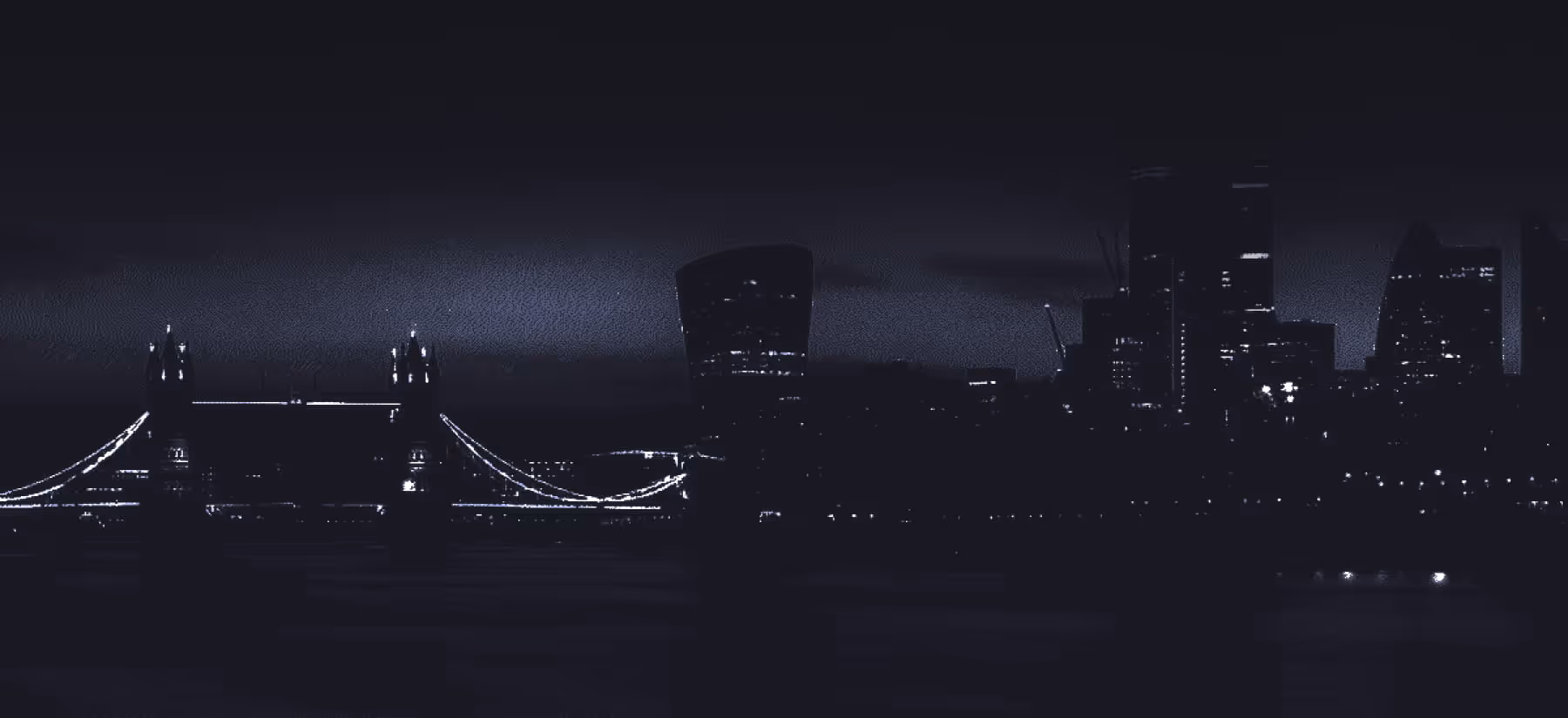 Night view of London skyline featuring Tower Bridge illuminated and surrounding city buildings with lights.
