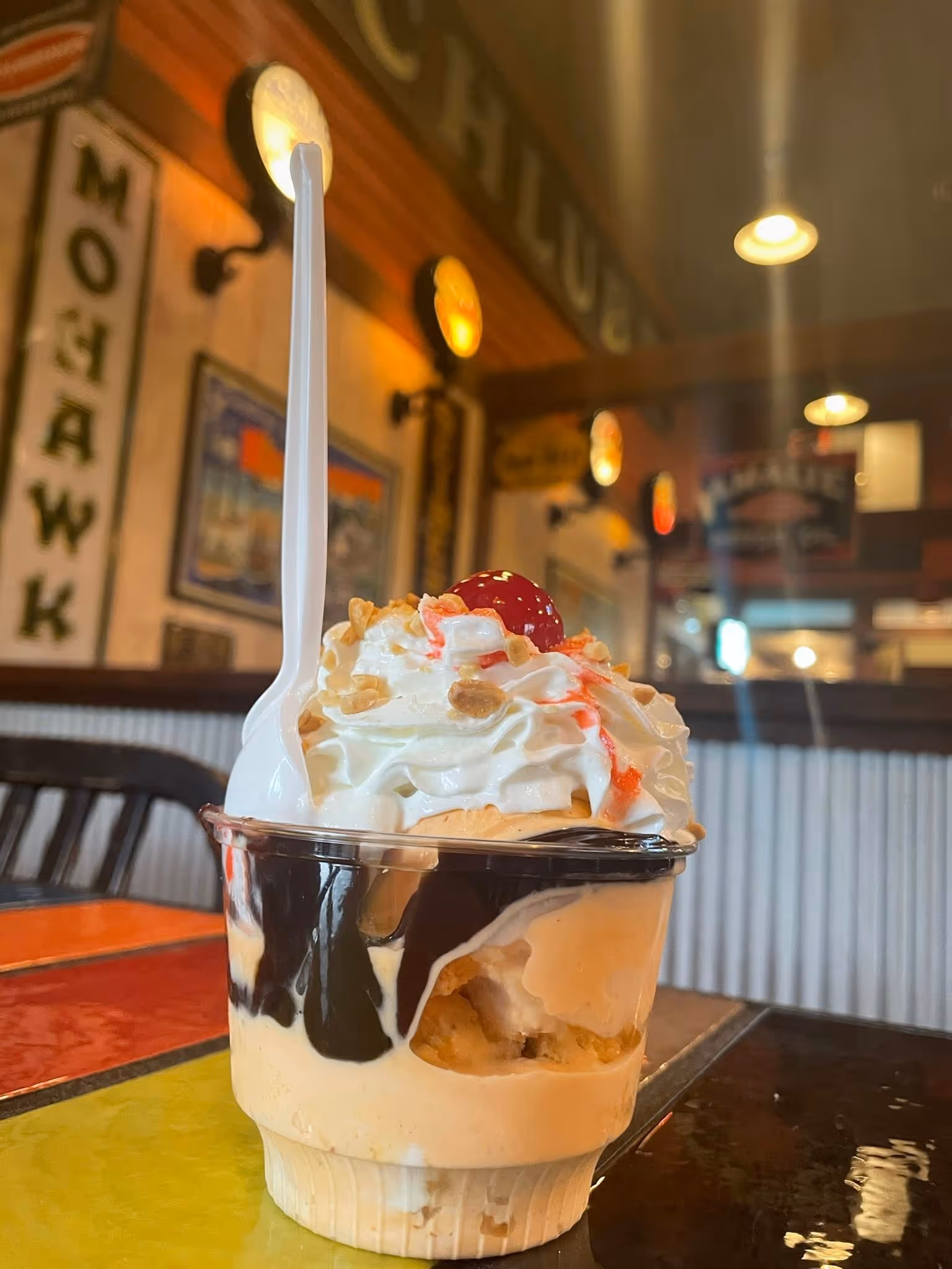 A chocolate and vanilla ice cream sundae with a cherry on top.
