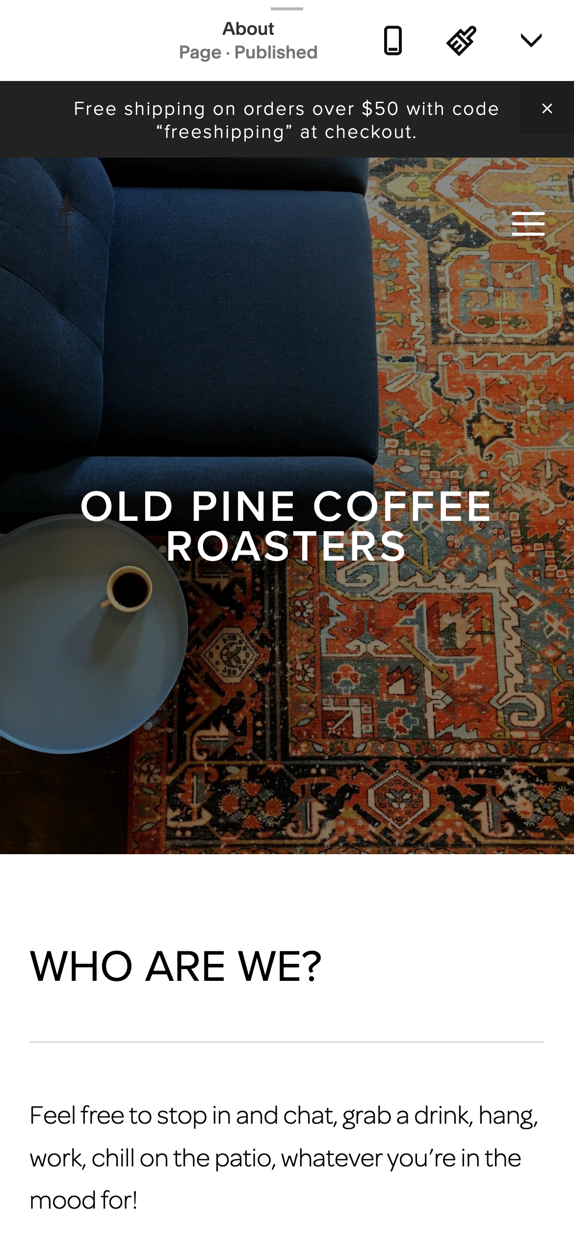 Blue cushioned chair next to a table with a cup of coffee on a patterned orange and red rug with text overlay 'OLD PINE COFFEE ROASTERS'.
