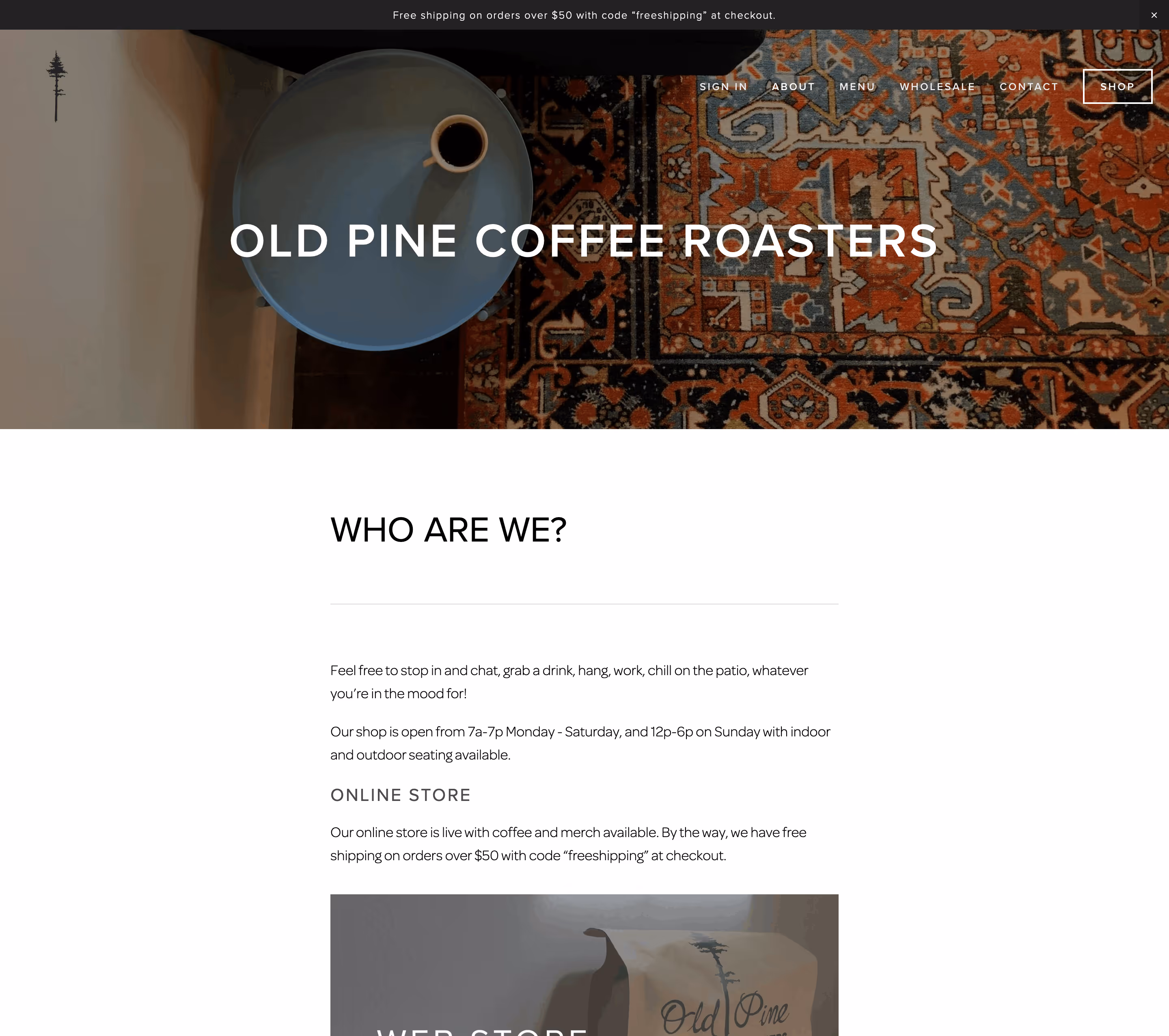 Top view of a gray round table with a cup of black coffee on a patterned rug background with the text 'OLD PINE COFFEE ROASTERS.'